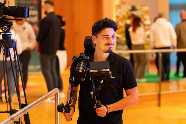Kameramann mit Gimbal lacht am Set