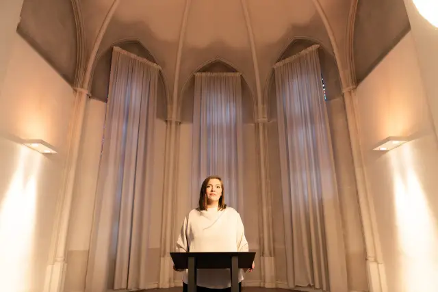 Rednerin am Pult in einem hellen Saal