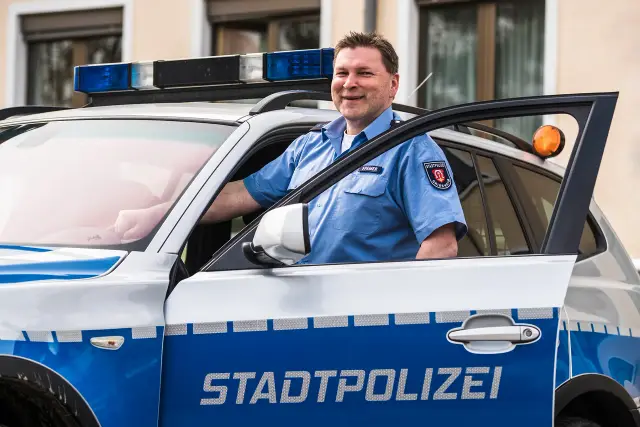 Polizist an seinem Streifenwagen