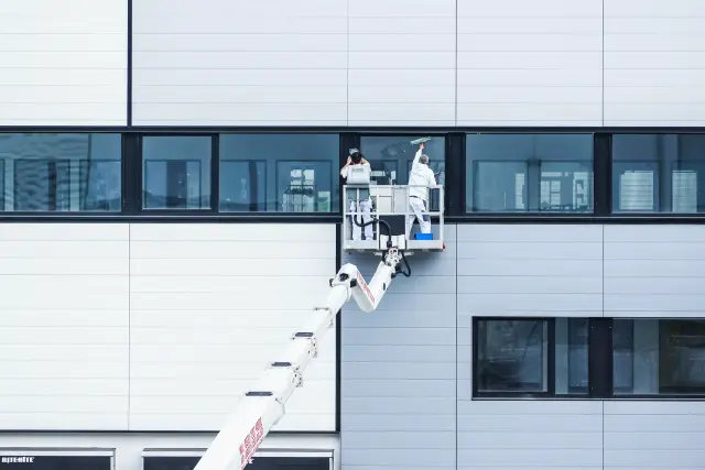 Arbeiter auf einer Hebebühne an einer Fassade