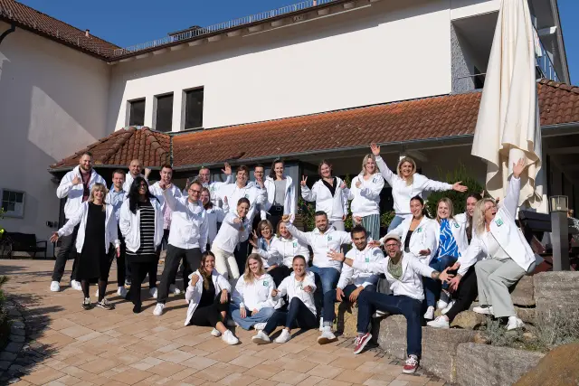 Gruppenfoto eines Teams vor einem Gebäude